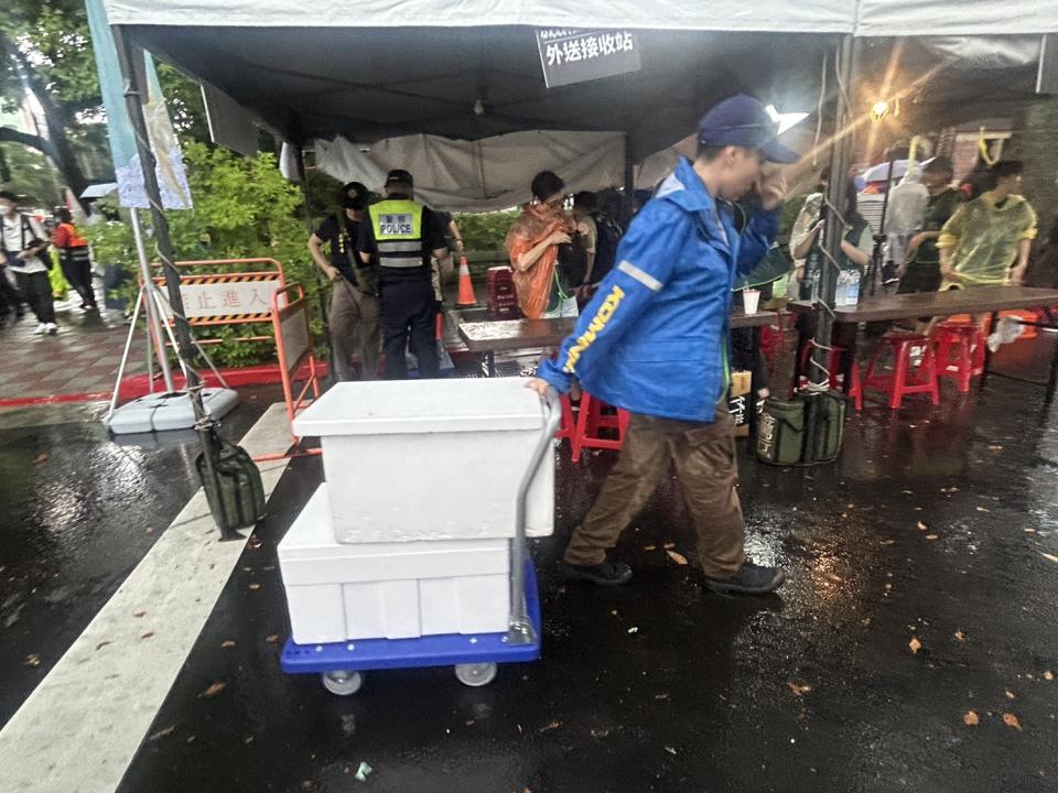 路口的物資接收站，不斷有送貨員將各種水果、飲料、口糧、便當、餅乾送達，主辦方寵粉的大手筆令人稱羨。(記者包克明攝)