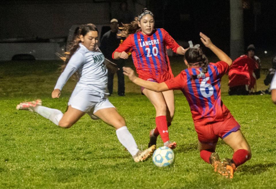 Manteca's Joanna Roa, left, fights for the ball with East Union's Geonna Flores, center, and Gabrielle McIntosh during a girls varsity soccer game at Woodward Park in Manteca on Jan. 24, 2024.