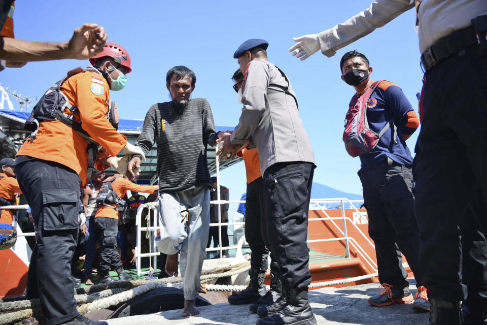 Police officers and rescuers assist a Rohingya refugee rescued from a capsized boat upon arrival at a port in Meulaboh, Indonesia, Thursday, March 21, 2024. An Indonesian search and rescue ship on Thursday located a capsized wooden boat that had been carrying dozens of Rohingya Muslim refugees, and began pulling survivors who had been standing on its hull to safety. (AP Photo/Reza Saifullah)