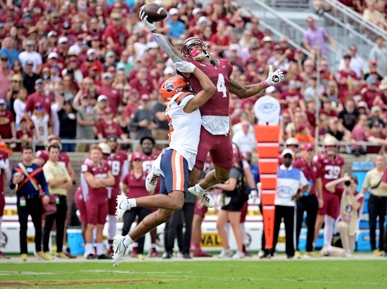 Florida State Seminoles wide receiver Keon Coleman (4) catches a pass over Syracuse Orange defensive back Jason Simmons Jr. (6) during the first quarter Oct. 14, 2023, at Doak S. Campbell Stadium in Tallahassee, Florida.