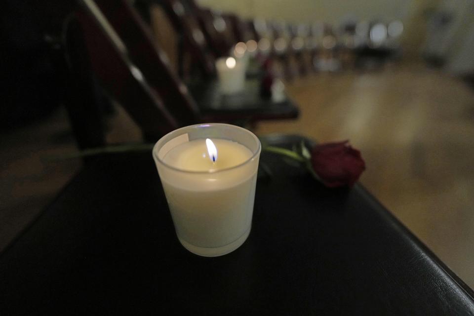 Thirteen chairs are empty with candles and roses to remember 25th anniversary of the Columbine High School mass shooting, Friday, April 19, 2024, in Denver. (AP Photo/Jack Dempsey)