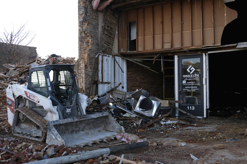 A track loader sits next to debris outside the Grace Life Church headquarters on Jan. 9, 2022, in Mayfield, Ky. (AP Photo/Audrey Jackson)