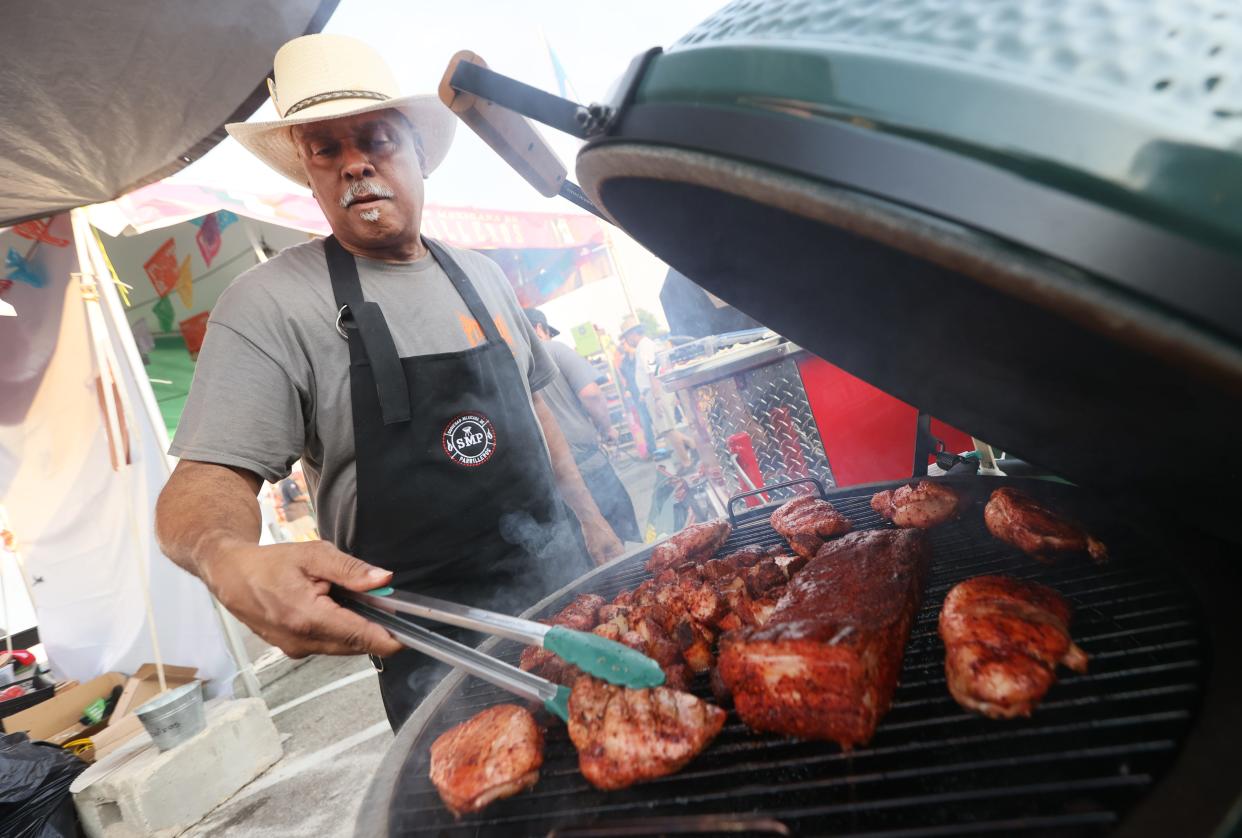 Briant 'Doc' Ennis works the grill inside the PitMakers tent at the Memphis in May World Championship Barbecue Cooking Contest at Liberty Park on Thursday, May 12, 2022.