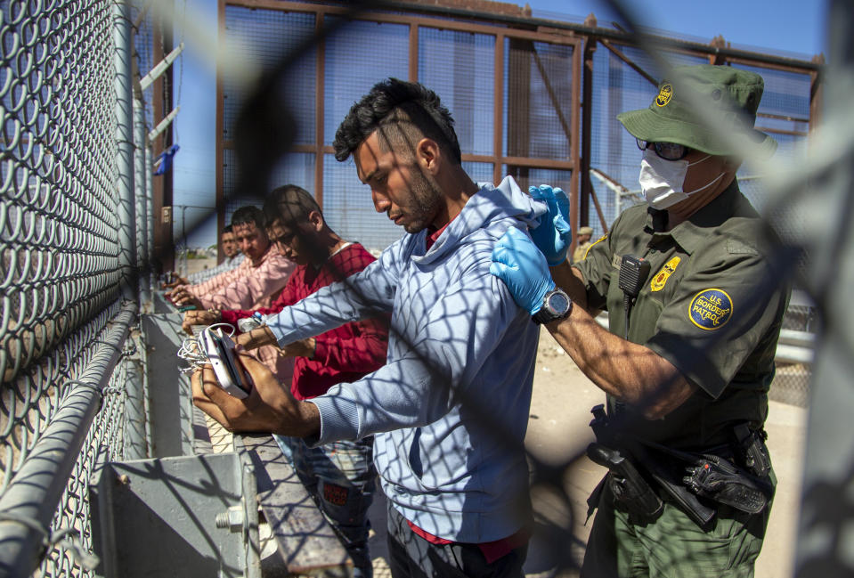 Migrants are pat down by a Border Patrol agent as they enter into El Paso, Texas (Andres Leighton / AP)