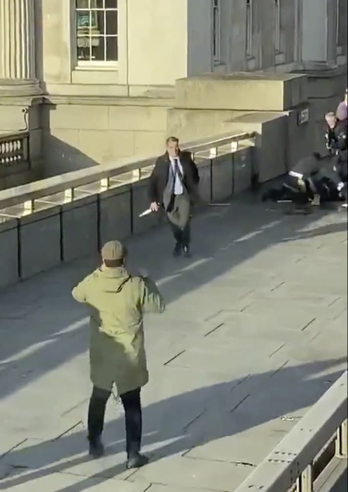 FILE - In this image made from Friday, Nov. 29, 2019, video provided by @HLOBlog, a bystander runs with a knife, after an incident on London Bridge in London. The people who used a fire extinguisher and even a 5-foot (1.52 meter) narwhal tusk Friday to fight back against an attacker who stabbed two people to death and wounded three others by the London Bridge was a reminder of how ordinary people can take extraordinary actions in efforts to save themselves and others. (@HLOBlog via AP, File)