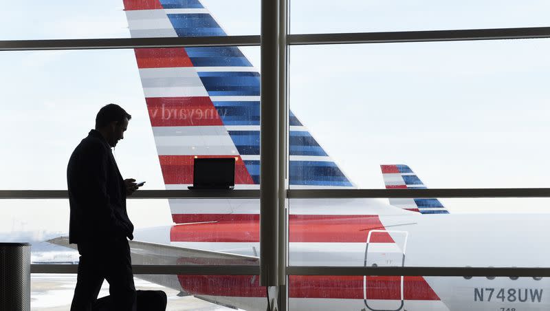 In this Jan. 25, 2016, file photo, a passenger talks on the phone as an American Airlines jets sit parked at their gates at Washington’s Ronald Reagan National Airport. Utah Rep. Burgess Owens has introduced an amendment that would increase the number of incoming and outgoing flights from the Reagan National Airport.