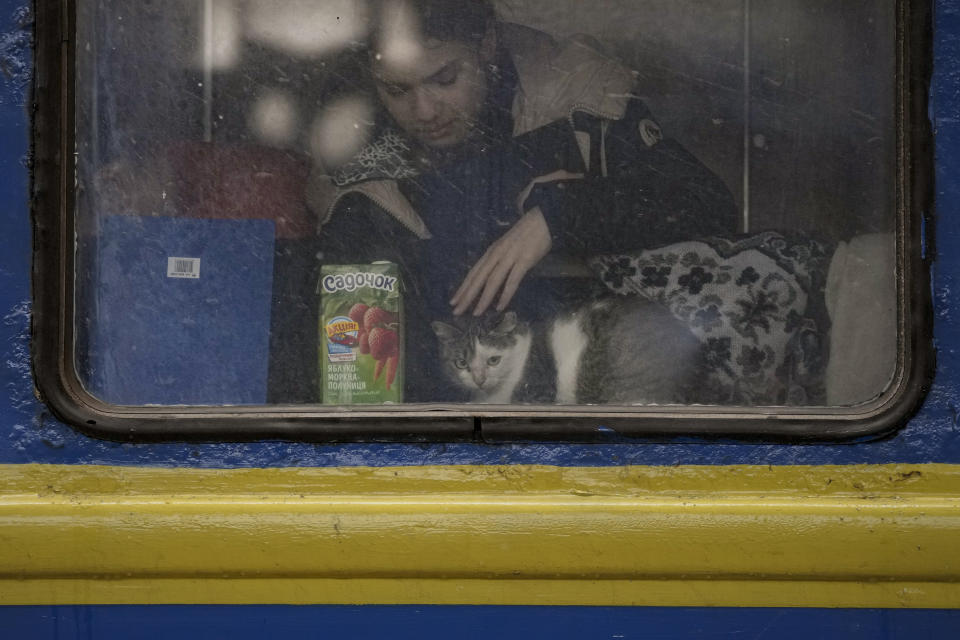 A girl comforts a cat before the departure of a Lviv bound train, in Kyiv, Ukraine, Thursday, March 3, 2022. (AP Photo/Vadim Ghirda)