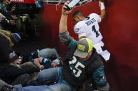 Fans falls onto Philadelphia Eagles quarterback Jalen Hurts (1) after a railing collapsed following the end of an NFL football game, Sunday, Jan. 2, 2022, in Landover, Md. Philadelphia won 20-16. (AP Photo/Alex Brandon)