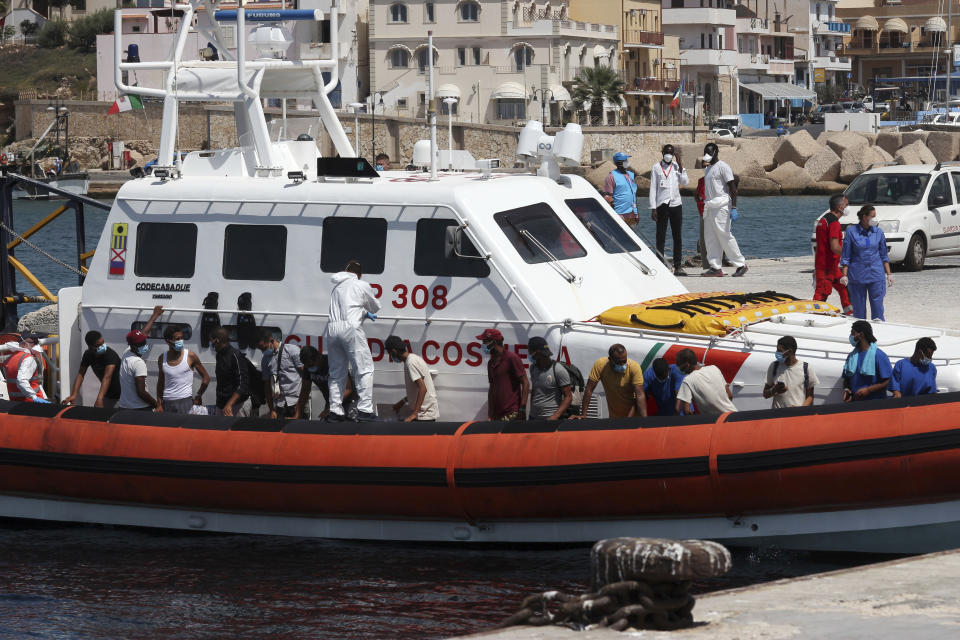 Migrants board a coast guard ship that will take them to the GNV Rhapsody ferry moored off Lampedusa island, Italy, Saturday, Sept. 5 , 2020. Italian officials have been hastily chartered ferries and put other measures into place to fight severe overcrowding at migrant centers on the tiny island of Lampedusa. (AP Photo/Mauro Seminara)