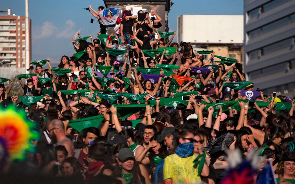 Feminist activists hold up green handkerchiefs -in favour of the decriminalization of abortion- during a protest against gender violence and patriarchy in Santiago - CLAUDIO REYES/AFP via Getty Images