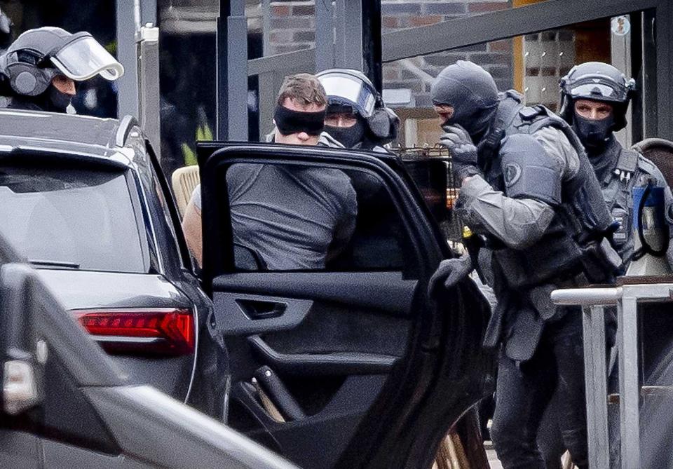 A man (C) is detained by the Special Intervention Service (DSI) of the Dutch National Police Corps outside a cafe in the center of Ede (EPA)