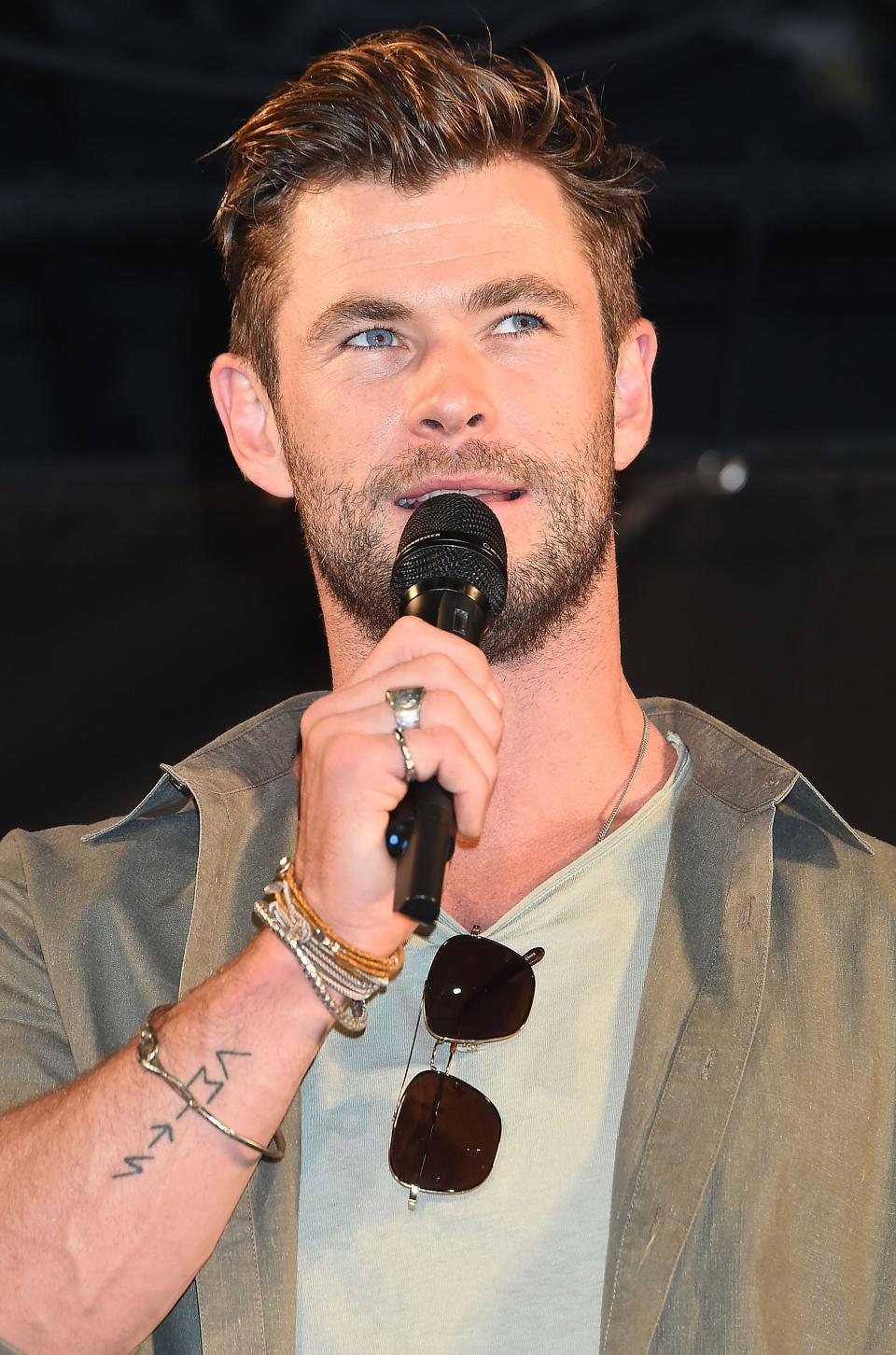 Chris Hemsworth with a microphone while speaking in Japan in 2019.