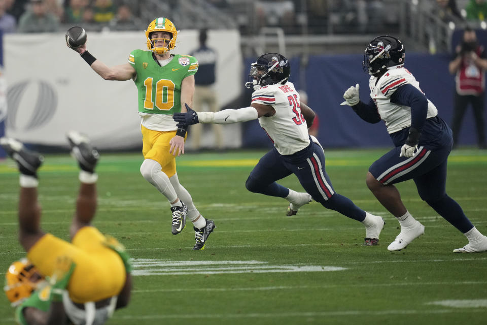 Oregon quarterback Bo Nix (10) throws under pressure during the first half on the NCAA Fiesta Bowl college football game against Liberty, Monday, Jan. 1, 2024, in Glendale, Ariz. (AP Photo/Ross D. Franklin)