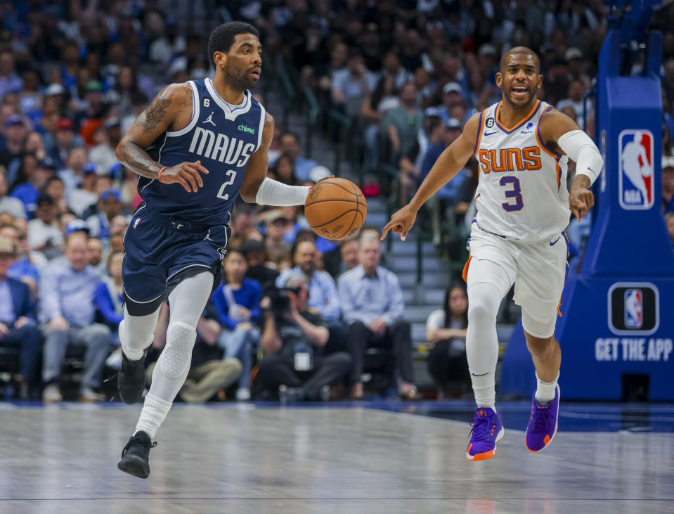 Mavericks guard Kyrie Irving (2) looks down court as Phoenix Suns guard Chris Paul (3) instructs his defense during the second half of an NBA basketball game, Sunday, March 5, 2023, in Dallas. (AP Photo/Gareth Patterson)