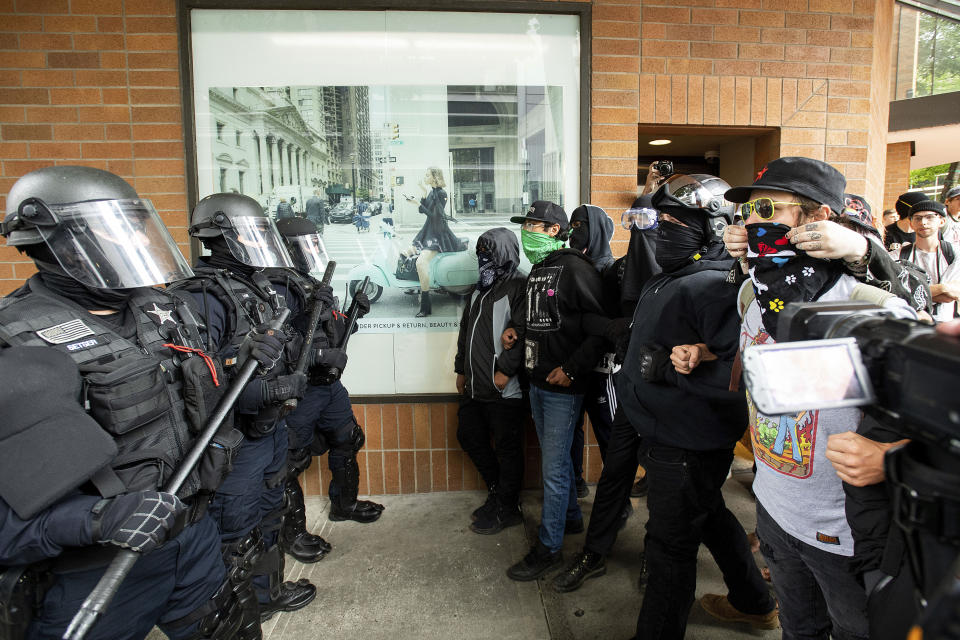 Police officers face off against protesters opposed to right-wing demonstrators following an "End Domestic Terrorism" rally in Portland, Ore., on Saturday, Aug. 17, 2019. Although the main protest remained largely peaceful, some skirmishes erupted in the following hours and police detained multiple protesters. (AP Photo/Noah Berger)
