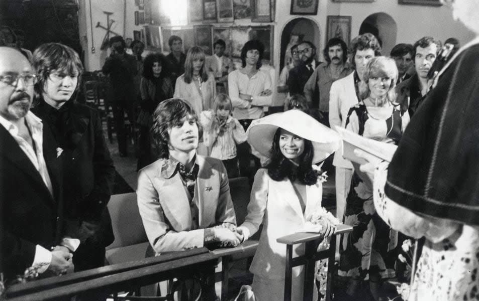 St. Tropez, France, 12th May, 1971: Rolling Stones lead singer Mick Jagger sits next to his Nicaraguan bride Bianca Perez Moreno De Macias during their wedding ceremony at the small fisherman's church of St, Annes. Watching in the background are (from right) french film director Roger Vadim, actress Nathalie Delon and photographer Patrick, Earl of Lichfield, Centre is Rolling Stones guitarist Keith Richard with his girlfriend Anita Pallenberg. See more exclusive photos like this in the ebook, 