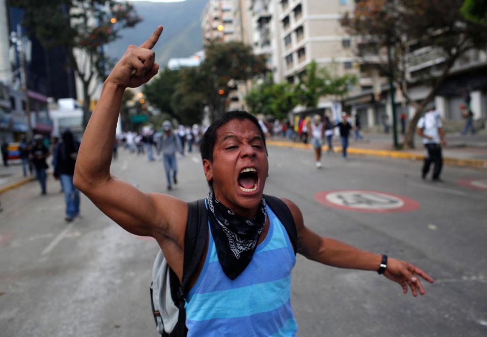 A demonstrator shouts slogans against Bolivarian National Guards during clashes in Caracas, Venezuela, Sunday, March 2, 2014. Since mid-February, anti-government activists have been protesting high inflation, shortages of food stuffs and medicine, and violent crime in a nation with the world's largest proven oil reserves. (AP Photo/Rodrigo Abd)