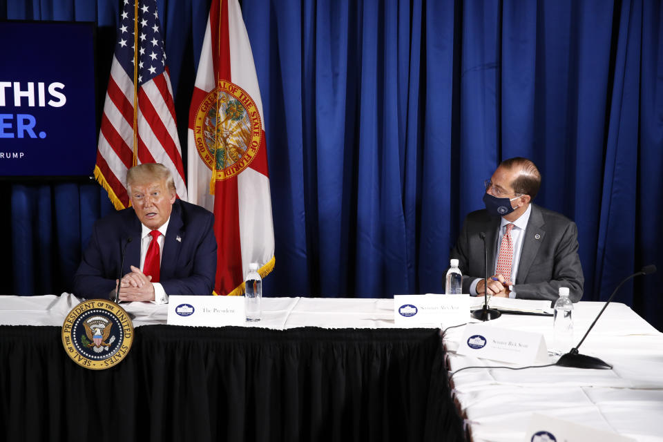 Health and Human Services Secretary Alex Azar, right, listens as President Donald Trump speaks during a roundtable discussion on the coronavirus outbreak and storm preparedness at Pelican Golf Club in Belleair, Fla., Friday, July 31, 2020. (AP Photo/Patrick Semansky)