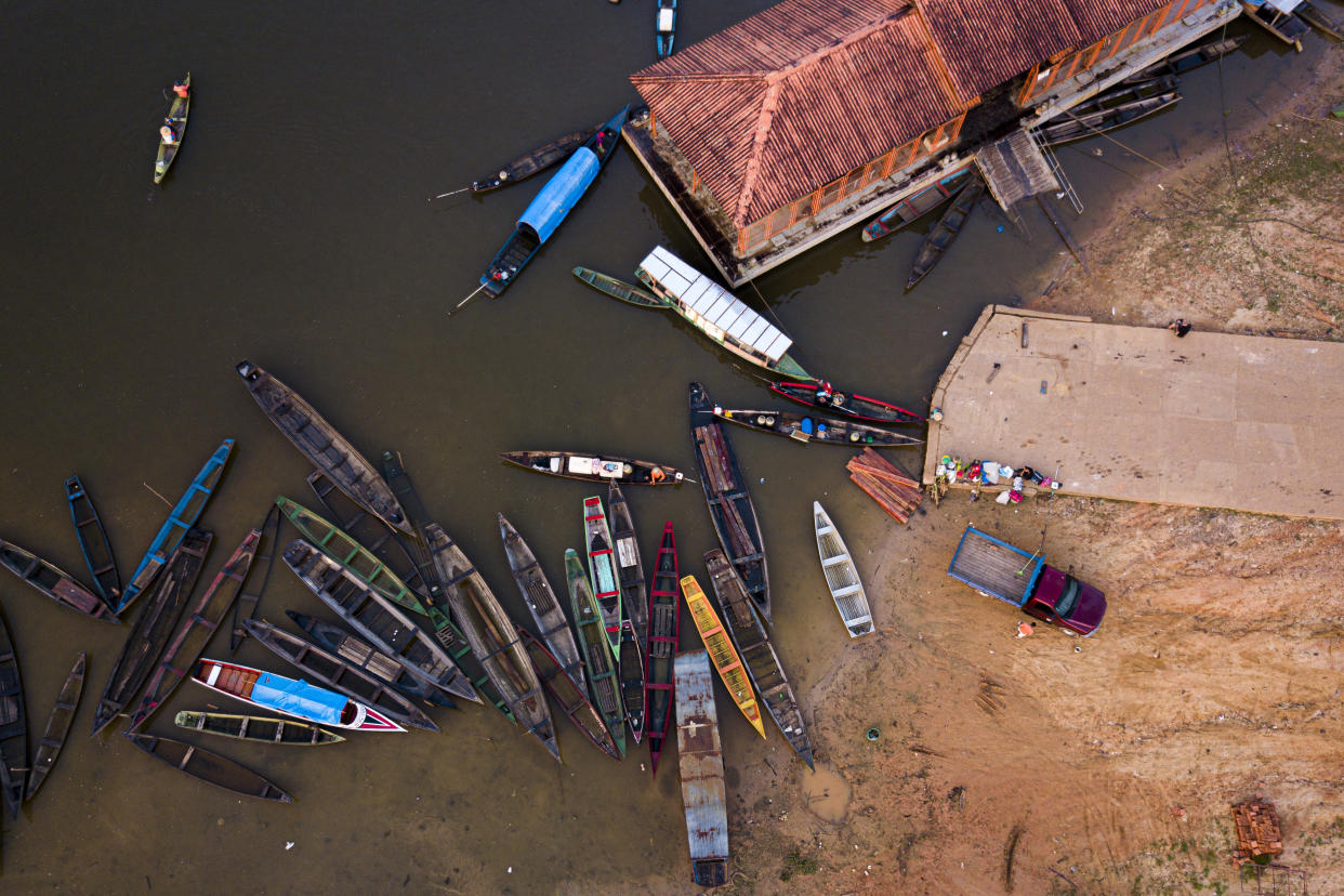 Moored boats, some with people sit at the port of Carauari city, Amazonia, Brazil, Thursday, Sept. 1, 2022. Pirarucu fishing is done once a year, around September, the period of lowest water. (AP Photo/Jorge Saenz)