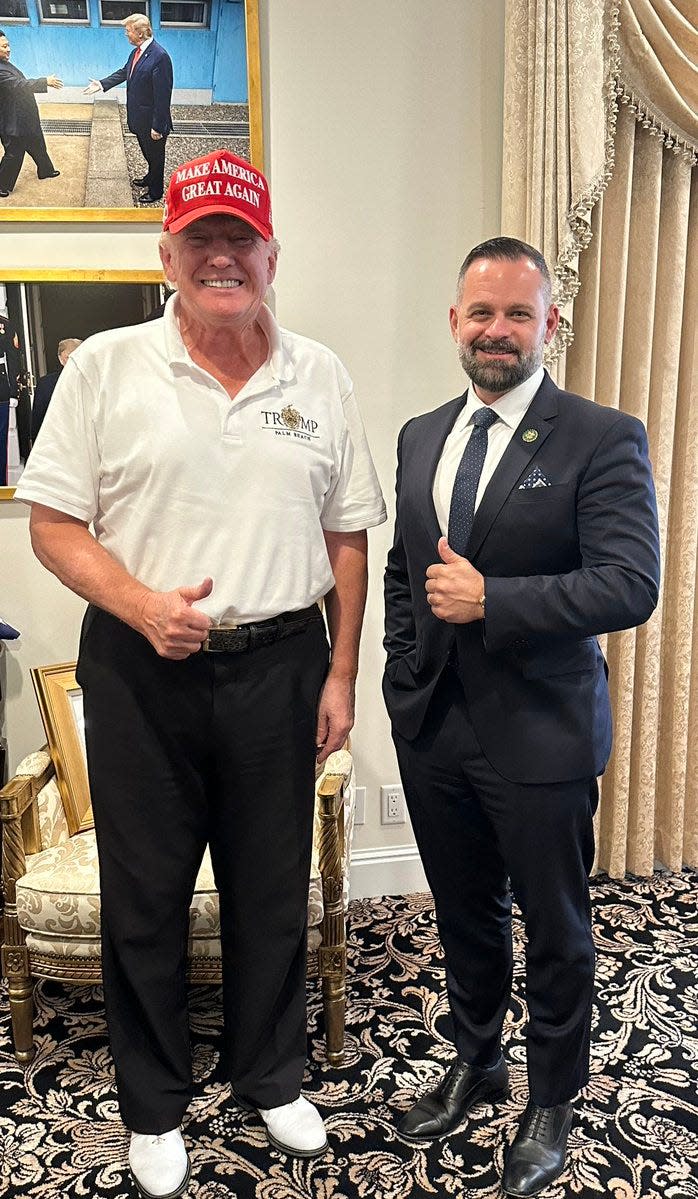 Cory Mills, right, poses with former President Donald Trump.
