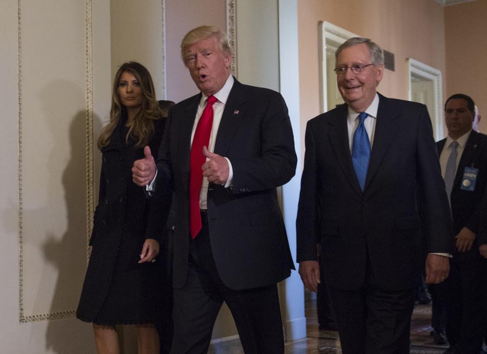 President-elect Donald Trump, flanked by his wife Melania and Senate Majority Leader Mitch McConnell of Ky., gives a thumbs-up while walking on Capitol Hill in Washington, Thursday, Nov. 10, 2016, after their meeting.   