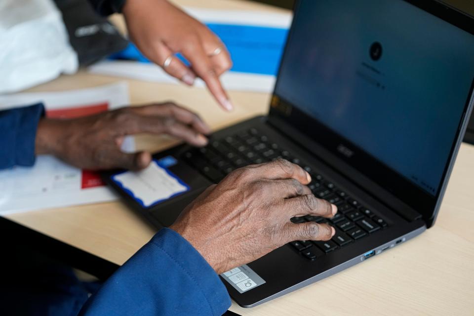 James Watson, 67, receives help logging into his laptop from Technology Access Project coordinator Ciara Young during the class for seniors at the Central Community House on the Near East Side on June 30.