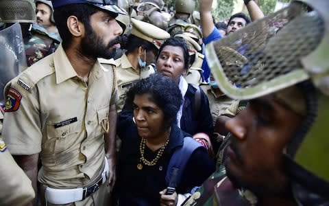 Two women breached a blockade surrounding a Hindu temple in the Indian state of Kerala, after the country's supreme court lifted a ban on women entering last September  - Credit: AFP/Getty