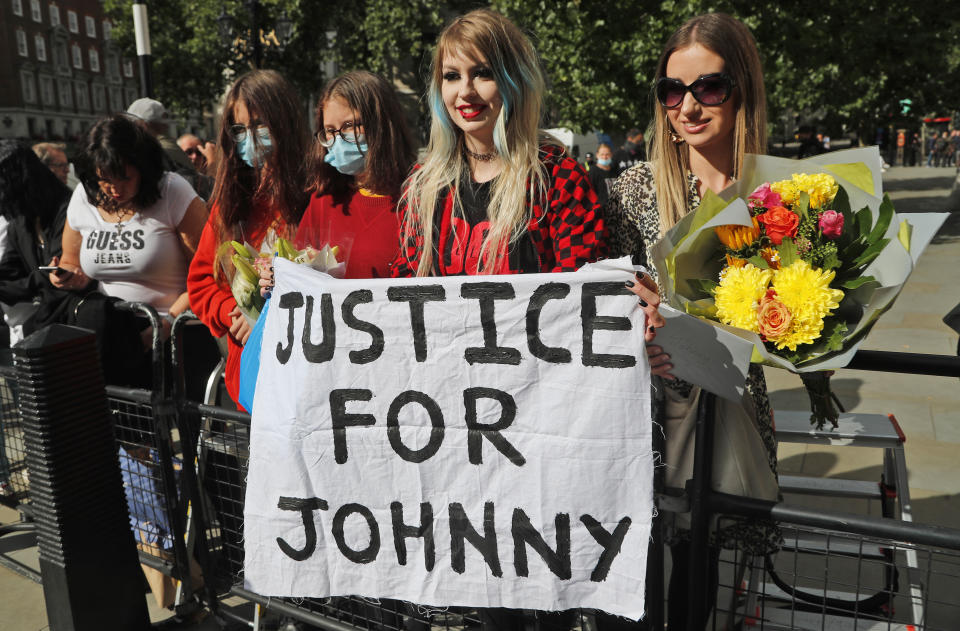 US Actor Johnny Depp supporters wait for the actor to arrive, outside the High Court in London, Tuesday, July 28, 2020. Hollywood actor Johnny Depp is suing News Group Newspapers over a story about his former wife Amber Heard, published in The Sun in 2018 which branded him a 'wife beater', a claim he denies.(AP Photo/Frank Augstein)