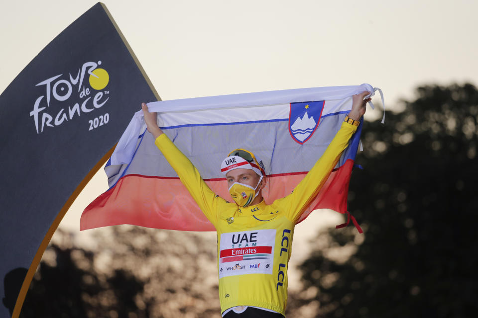 El campeón del Tour de Francia Tadej Pogacar despliega la bandera de Eslovenia tras el final de la última etapa en París, el domingo 20 de septiembre de 2020. (AP Foto/Christophe Ena)