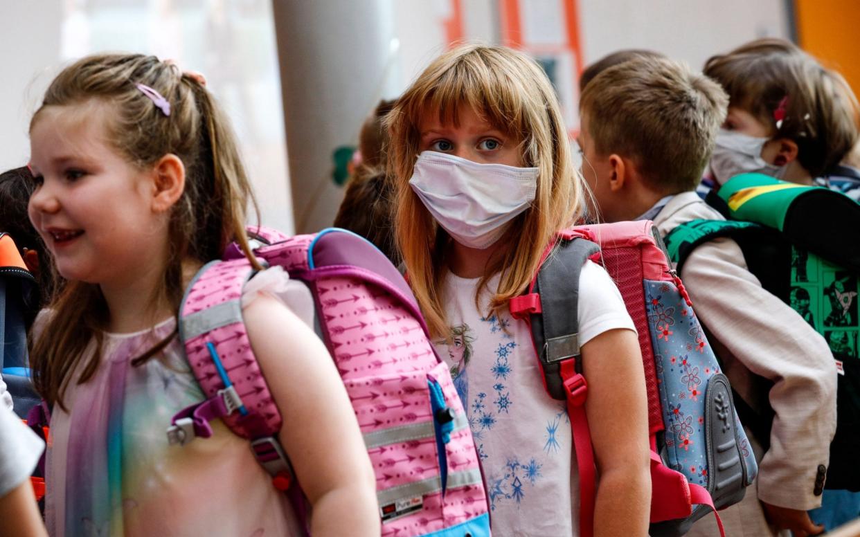Mandatory Credit: Photo by FELIPE TRUEBA/EPA-EFE/Shutterstock (10729924ab) New pupil Angelina Bojahr (C) wears a sanitary mask during an enrolment ceremony in the Lankow elementary school in Schwerin, Germany, 01 August 2020. Thousands of children of Mecklenburg-Western Pomerania celebrated their first day in school with classes resuming on 03 August. This federal state is the first in Germany to officially open the new school year complying with health protocols imposed by the coronavirus pandemic. Children have to wear mask in the common areas of the school buildings. First day in school for pupils of Mecklenburg-Western Pomerania, Schwerin, Germany - 01 Aug 2020 - FELIPE TRUEBA/EPA-EFE/Shutterstock
