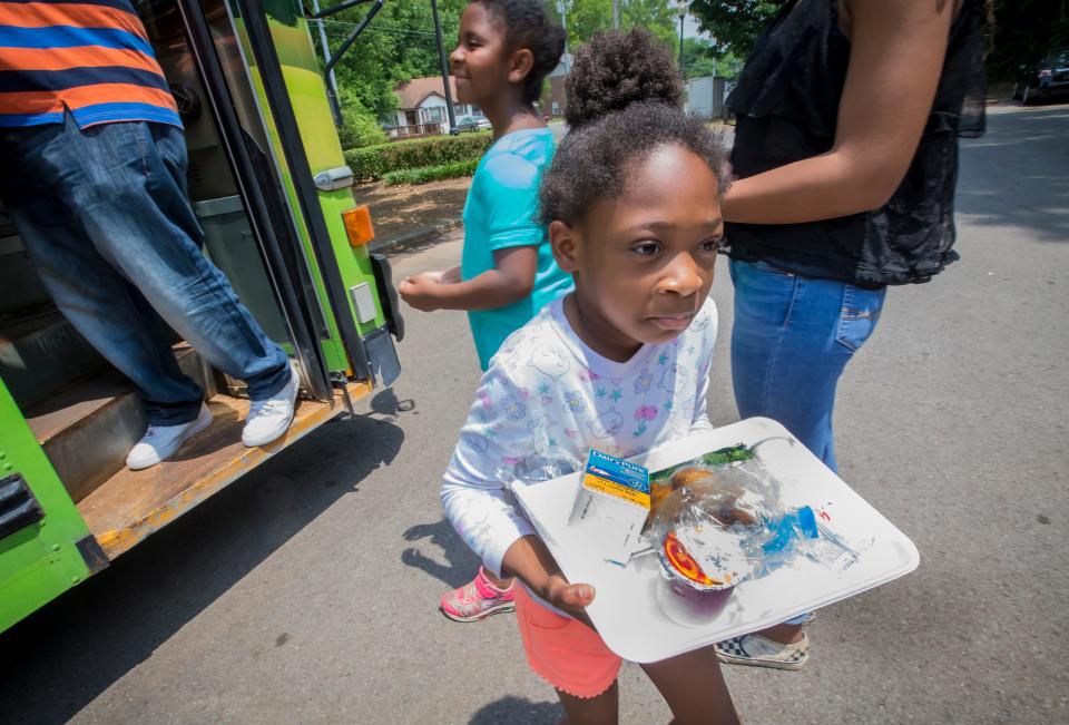 A child leaves the CHOW Bus with a lunch as the bus made a stop at Campus Villa Apartments on Greenland Drive in Murfreesboro.