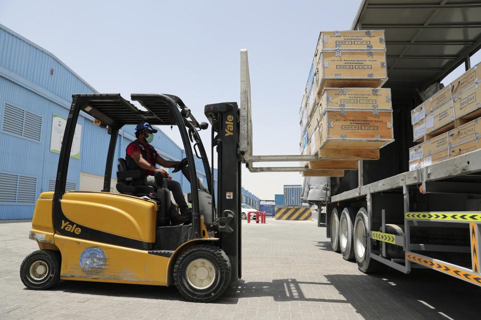 A forklift driver loads material for temporary shelters to be sent to India, at the UNHCR warehouses, part of the International Humanitarian City, in Dubai, United Arab Emirates, Sunday, May 9, 2021. Dubai's long-haul carrier Emirates will begin shipping aid from the World Health Organization and other groups into India for free to help fight a crushing outbreak of the coronavirus, the airline said Sunday. (AP Photo/Kamran Jebreili)