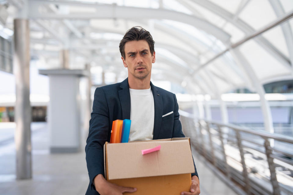 A man holding a box of his belongings