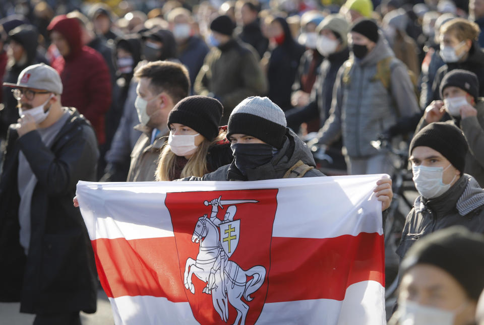 People with an old Belarusian national flag march during an opposition rally to protest the official presidential election results in Minsk, Belarus, Sunday, Oct. 18, 2020. Tens of thousands rallied in Minsk once again on Sunday, demanding the resignation of the country's authoritarian leader. Mass weekend protests in the Belarusian capital have continued since Aug. 9, when officials handed President Alexander Lukashenko a landslide victory in an election widely seen as rigged. (AP Photo)