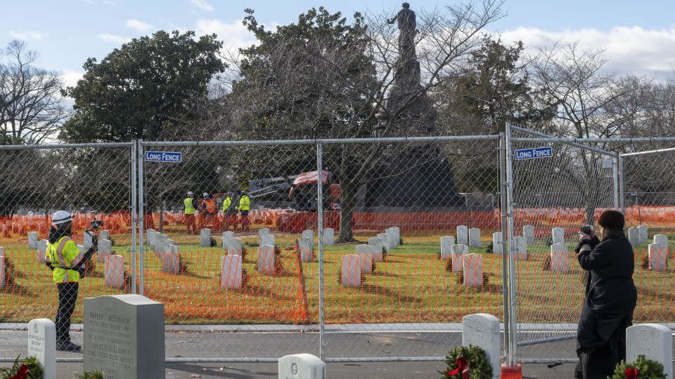 A person affiliated with Defend Arlington, right, tells workers to stop working to remove a Confederate Memorial in Arlington National Cemetery on Monday. - Kevin Wolf/AP