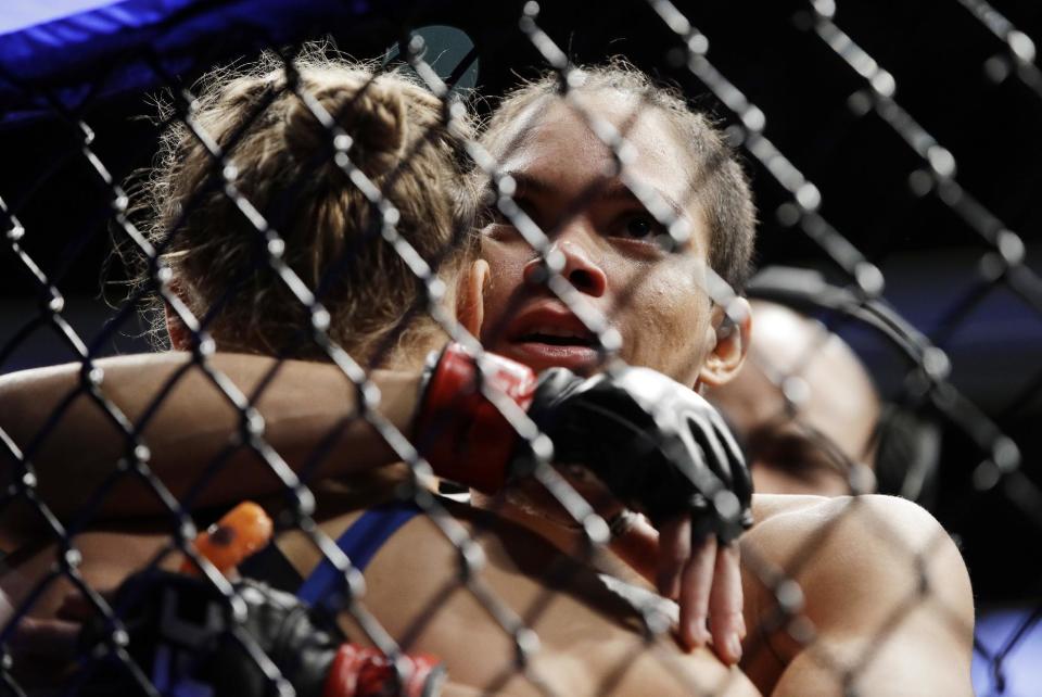 Amanda Nunes, right, hugs Ronda Rousey after Nunes scored a stoppage in the first round of their women's bantamweight championship mixed martial arts bout at UFC 207, Friday, Dec. 30, 2016, in Las Vegas. (AP Photo/John Locher)
