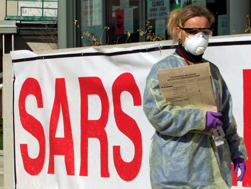 FILE PHOTO: A nurse wearing protective gear walks outside a Severe Acute Respiratory Syndrome Clinic (SARS) in suburban Toronto