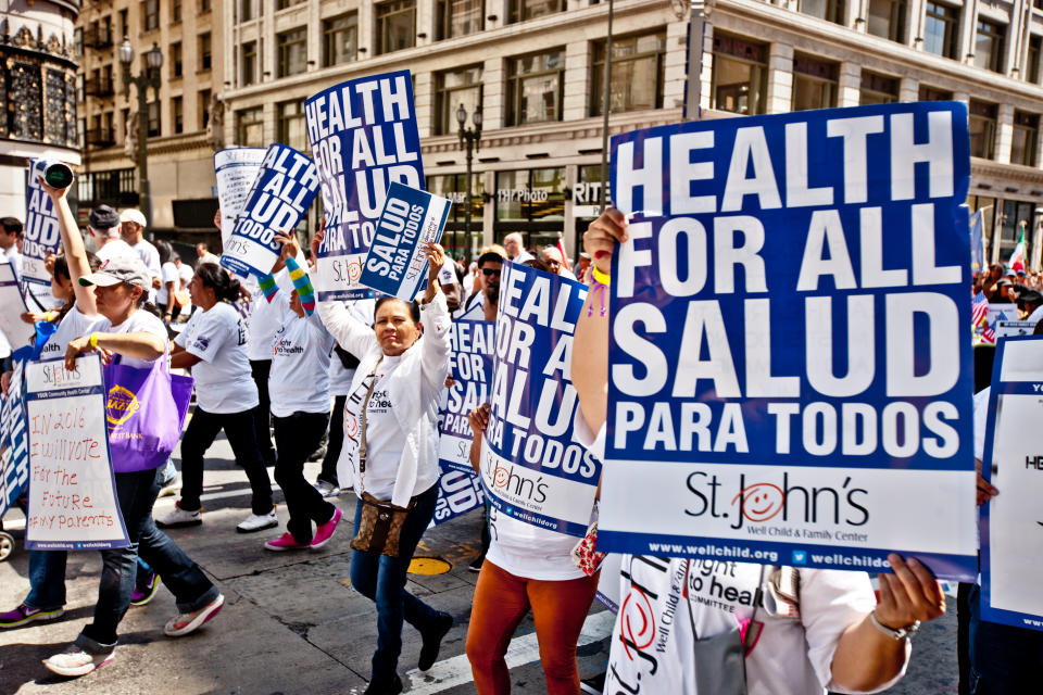 Los Angeles, USA  - May 1, 2013: May Day March in Los Angeles Downtown, USA. People holding posters and banners dedicated to immigration and healthcare reform.