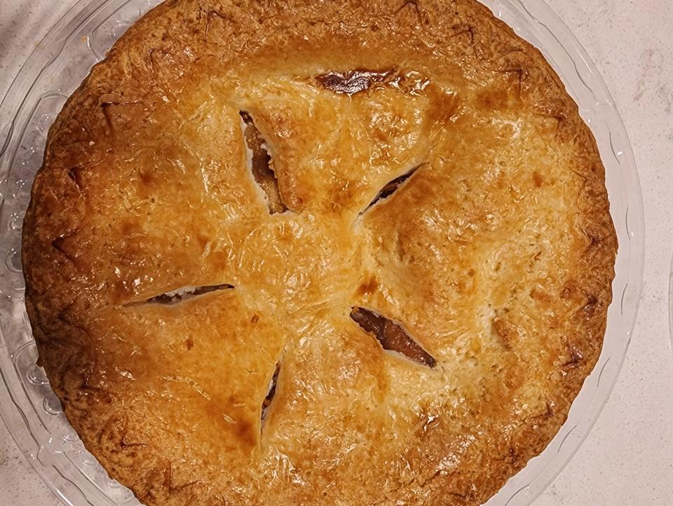 A whole pie in packaging on a white counter