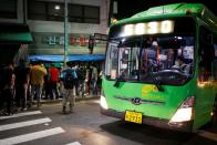 A bus driver looks on as day workers gather to seek for a job in Seoul