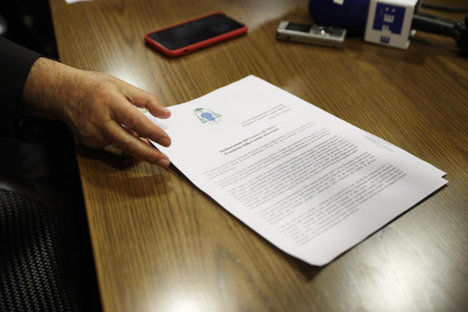 Cardinal Angelo Becciu shows a document as he talks to journalists during press conference in Rome, Friday, Sept. 25, 2020. The powerful head of the Vatican's saint-making office, Cardinal Angelo Becciu, has resigned from the post and renounced his rights as a cardinal amid a financial scandal that has reportedly implicated him indirectly. (AP Photo/Gregorio Borgia)