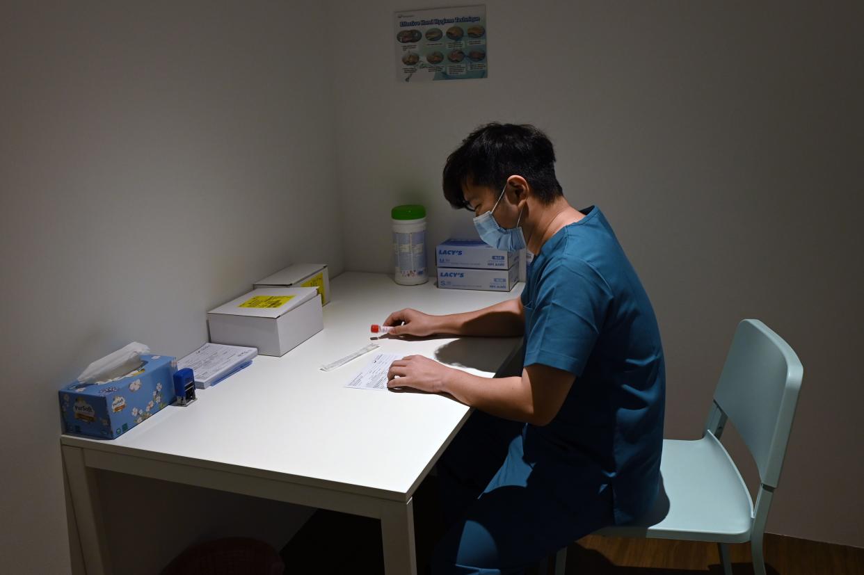 A health staff prepare polymerase chain reaction (PCR) test-kit for guests at the Connect@Changi, billed as the world's first coronavirus-safe hotel and conference complex is pictured in Singapore on February 18, 2021. (Photo by Roslan RAHMAN / AFP) / To go with Singapore-travel-health-virus (Photo by ROSLAN RAHMAN/AFP via Getty Images)