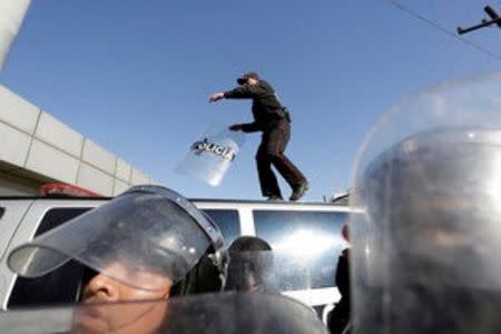 A police officer walks on a vehicle parked at the entrance of the Topo Chico prison in Monterrey, Mexico, February 11, 2016. REUTERS/Daniel Becerril