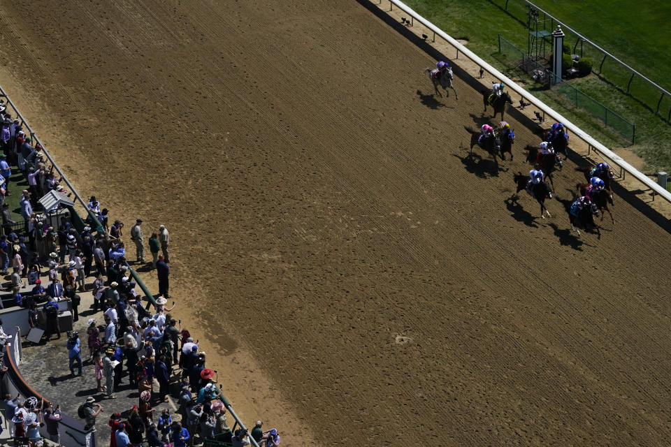 Fans watch as horses run a race before the 147th running of the Kentucky Derby at Churchill Downs, Saturday, May 1, 2021, in Louisville, Ky. (AP Photo/Brynn Anderson)