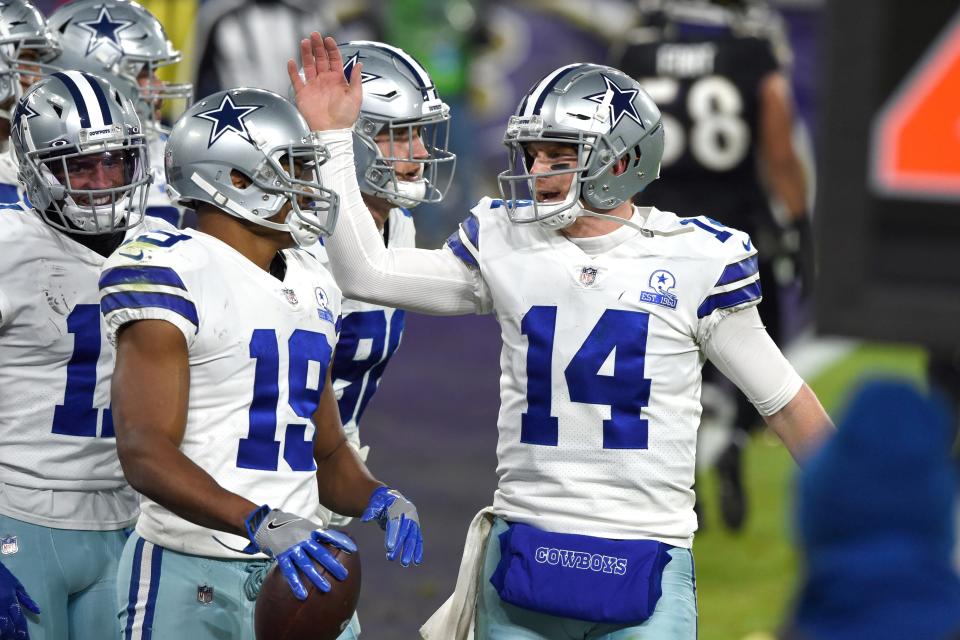 Dallas Cowboys quarterback Andy Dalton (14) and wide receiver Amari Cooper (19) react after they connected for a touchdown pass and catch against the Baltimore Ravens on Tuesday in Baltimore.