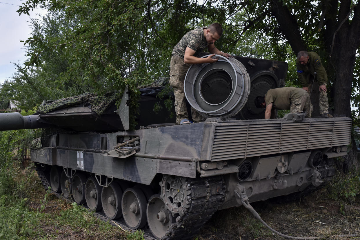 Ukrainian soldiers repair a Leopard 2 tank