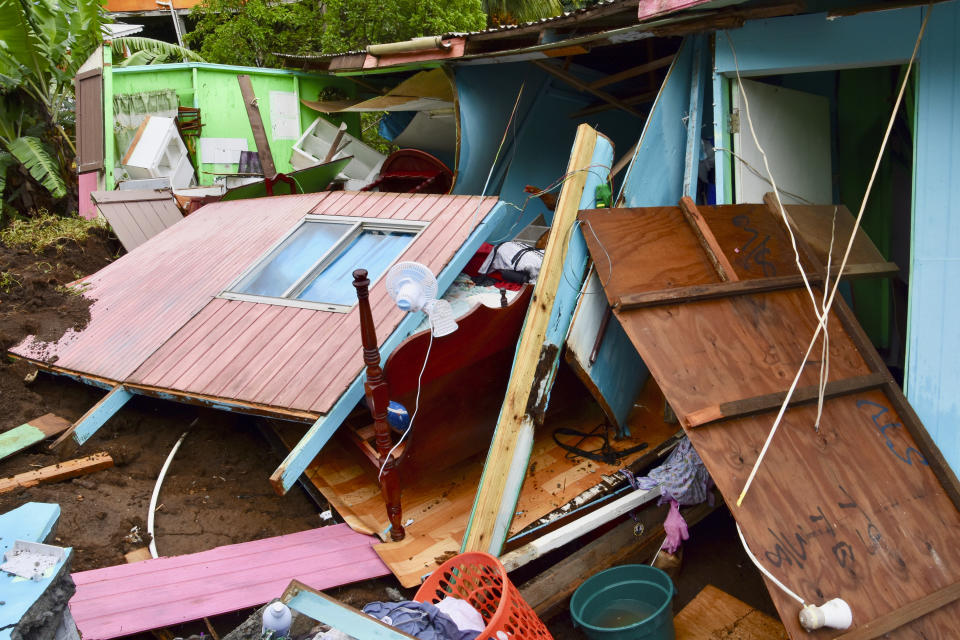 A home damaged by a mudslide sits on a hillside after heavy rains poured down causing flooding and mudslides that damaged some homes and further battered areas already burdened by heavy ashfall from eruptions of La Soufriere volcano, in Kingstown, on the Caribbean island of St. Vincent, Thursday, April 29, 2021. (AP Photo/Orvil Samuel)