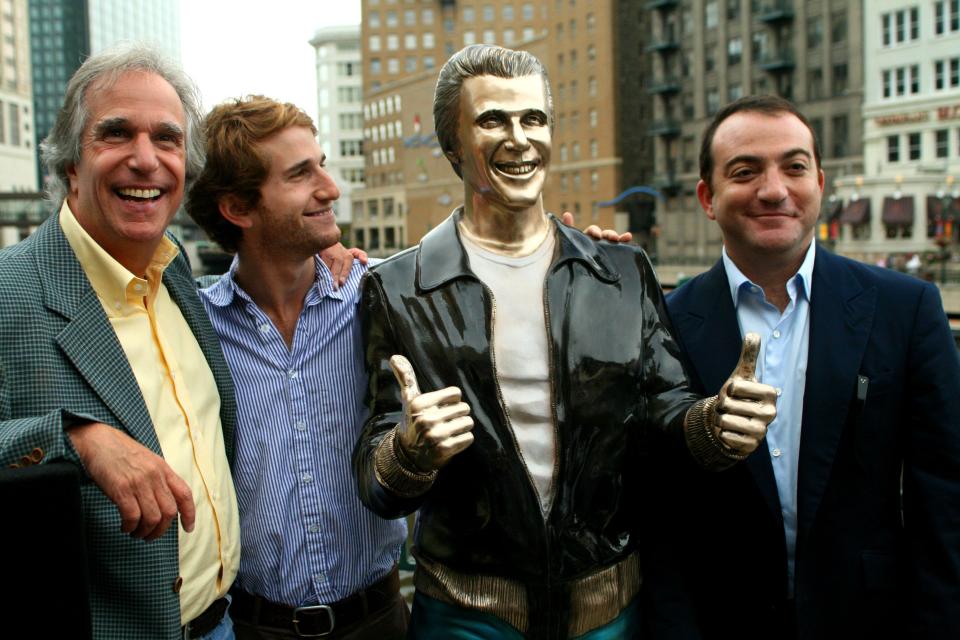 Actor Henry Winkler, left, poses with his sons Max Winkler, second left, and Jed Weitzman as they stand with a bronze statue of the "Happy Days" character Arthur Fonzarelli, also known as "The Fonz," at an unveiling, Aug. 19, 2008, in Milwaukee. The program, which ran from 1974-1984, was based in Milwaukee.
