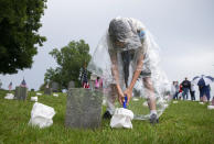 <p>Alex Kies, a Boy Scout with Troop 218, tries to light soggy luminaria following a thunderstorm, at the annual Fredericksburg National Cemetery Illumination in Fredericksburg, Va., Saturday, May 26, 2018. Boy Scouts from the Mattaponi and Aquia districts and Commonwealth Council Girl Scouts placed luminarias at more than 15,000 graves in the cemetery. (Photo: Mike Morones/The Free Lance-Star via AP) </p>