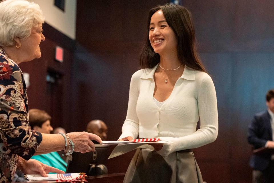 Members of daughters of the American Revolution hand out American flags and pins to newly naturalized American citizens during a naturalization ceremony at Dan M. Russell Courthouse in Gulfport on Thursday, Oct. 19, 2023.